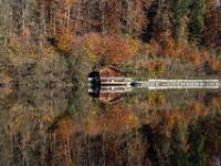 Hütte am gegenüberliegenden Seeufer mit herbstlicher Kulisse